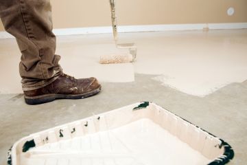 Painter painting garage floor.